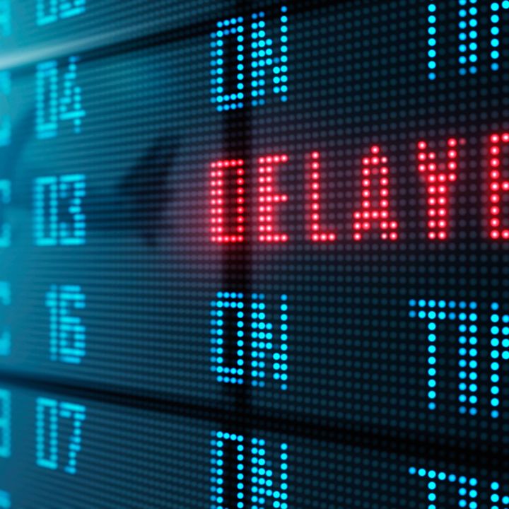 An airport LED board showing delayed and on-time flights