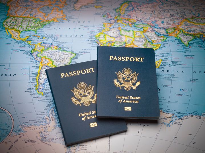 Two travel passports sitting on top of a world map.