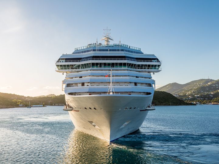A large cruise ship is seen from the front as it sails on the water.