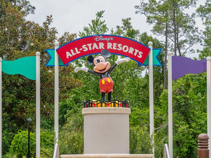 A statue of Mickey underneath a sign for Disney's All-Star Resorts.