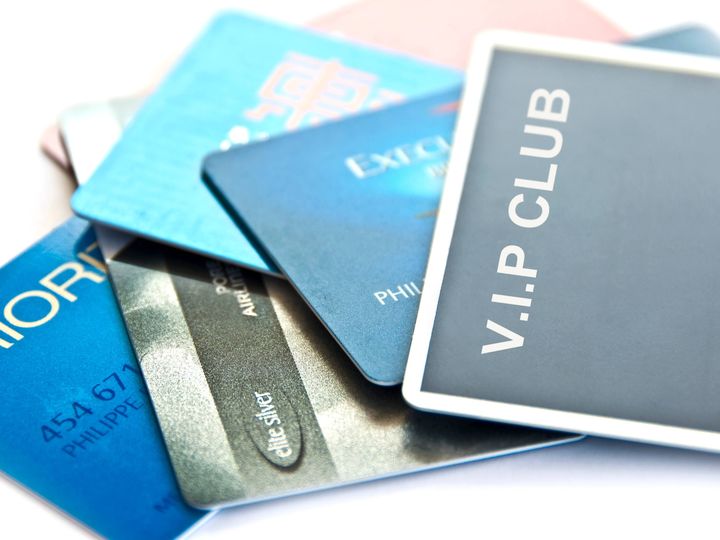 An array of travel and credit cards fanned out on a white table.
