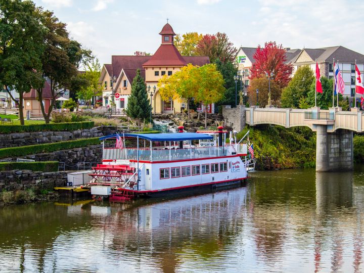 A river boat floats along the water in Frankenmuth, Michigan with its atmospheric Bavarian architecture.