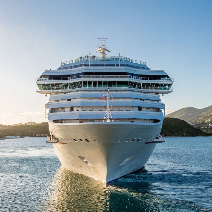 A large cruise ship is seen from the front as it sails on the water.