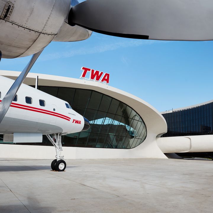 An old TWA plane is parked next to the TWA Hotel at JFK.