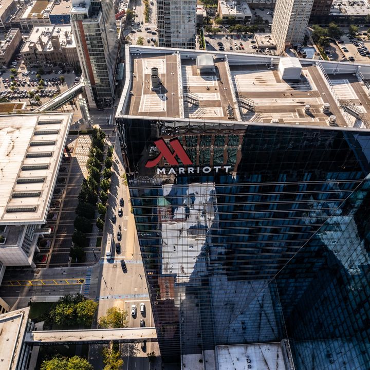 An aerial view looking down over a Marriott hotel set in an urban city.