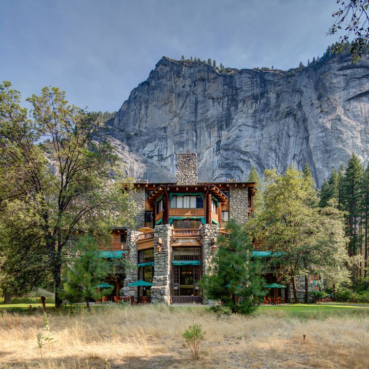 The exterior of the Ahwahnee is Yosemite standing in front of a massive stone mountain. 