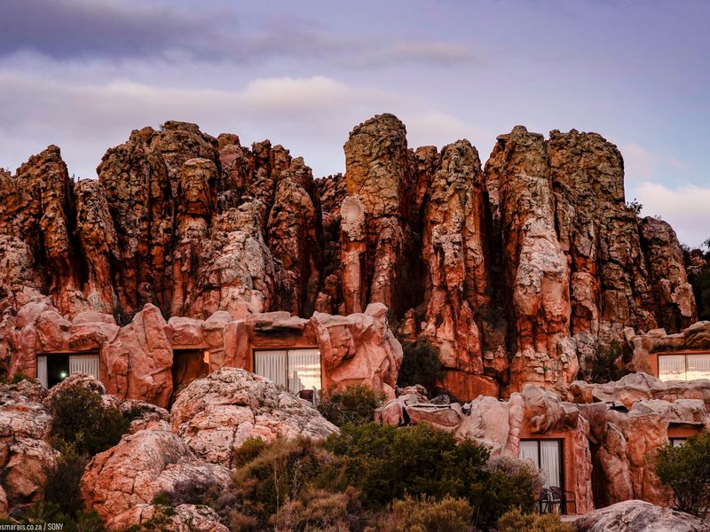 A collection of cave hotel rooms nearly hidden into the side of a rugged mountain at Kagga Kamma Eco Lodge.