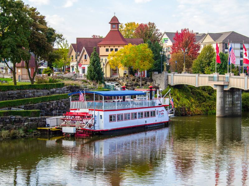 A river boat floats along the water in Frankenmuth, Michigan with its atmospheric Bavarian architecture.